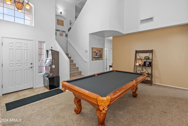 rec room with a towering ceiling, light colored carpet, and billiards