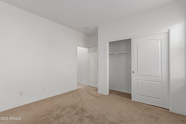 unfurnished bedroom featuring light carpet and a closet