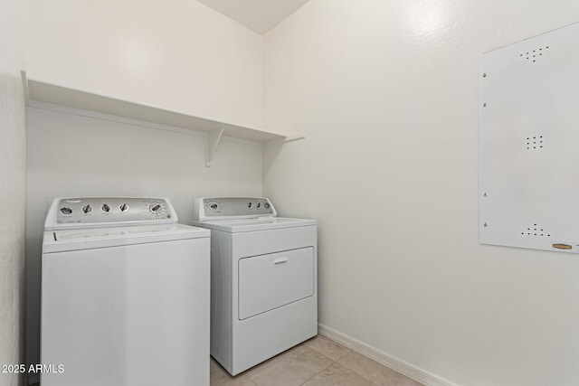 washroom with electric panel, washer and clothes dryer, and light tile patterned floors