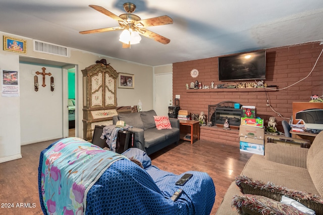 living room featuring a brick fireplace, hardwood / wood-style flooring, and ceiling fan