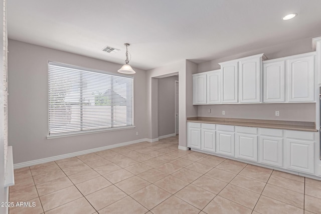kitchen featuring visible vents, pendant lighting, light countertops, baseboards, and white cabinetry