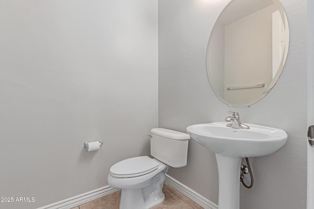 bathroom with toilet, baseboards, and tile patterned floors