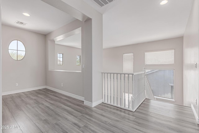 unfurnished room with recessed lighting, baseboards, visible vents, and wood finished floors