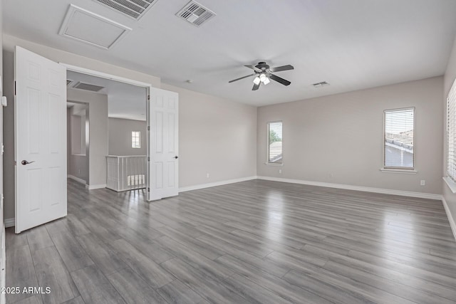 unfurnished living room featuring ceiling fan, attic access, and visible vents