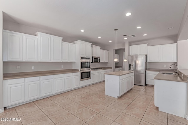 kitchen with stainless steel appliances, light tile patterned floors, white cabinetry, and a sink