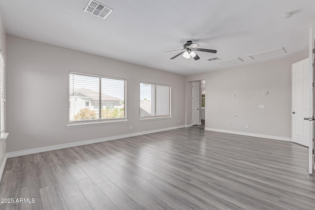 unfurnished living room featuring ceiling fan, attic access, wood finished floors, and visible vents