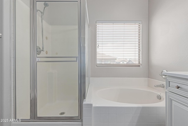 bathroom with a shower stall, a garden tub, and vanity