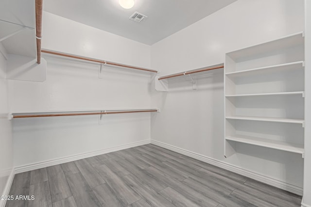 walk in closet with visible vents and wood finished floors