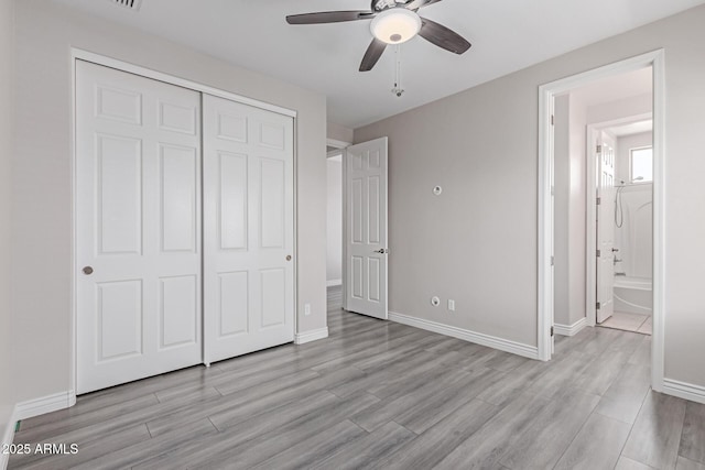 unfurnished bedroom featuring baseboards, ceiling fan, a closet, and wood finished floors