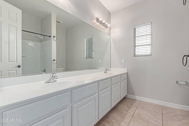 full bath with a sink, baseboards, tile patterned flooring, and toilet