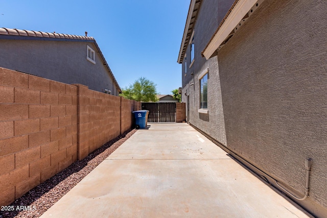 view of home's exterior with fence, stucco siding, and a patio area