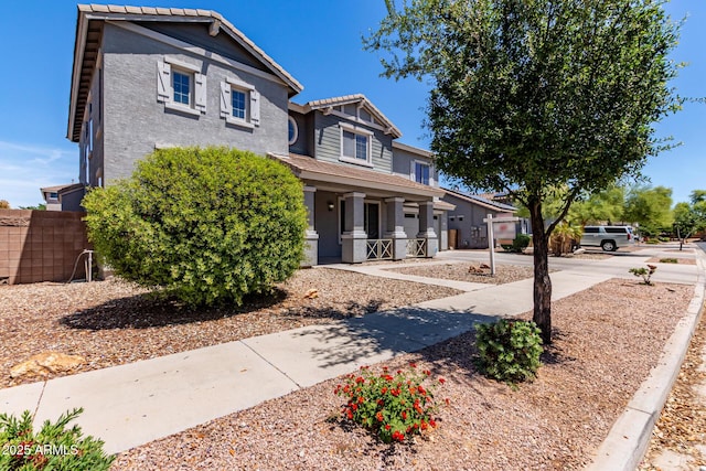 view of front of house featuring a porch, a tiled roof, driveway, a garage, and stucco siding