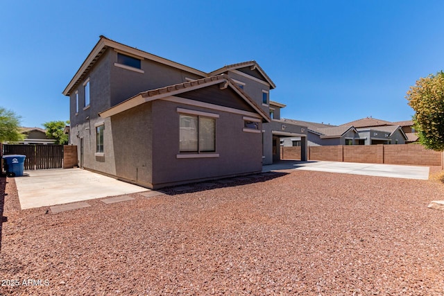 back of property featuring a patio, a fenced backyard, stucco siding, and driveway