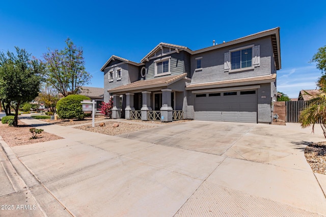 craftsman-style house with a porch, driveway, fence, an attached garage, and stucco siding