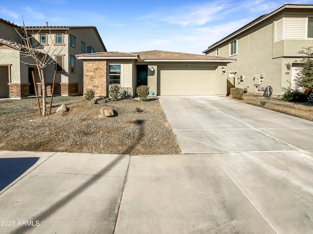 view of front of home featuring driveway, an attached garage, and stucco siding