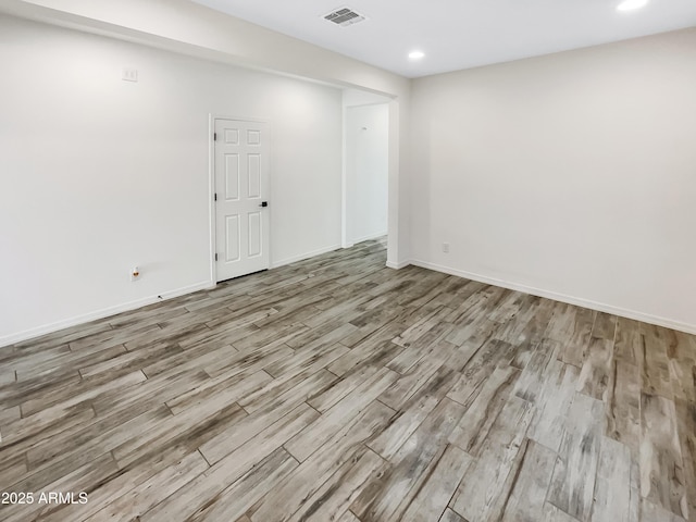 empty room featuring visible vents, baseboards, and wood finished floors