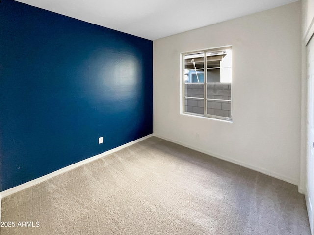 carpeted empty room with baseboards