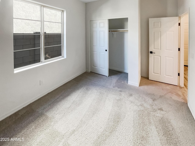 unfurnished bedroom featuring carpet floors, baseboards, and a closet