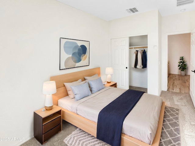 carpeted bedroom with visible vents and a closet