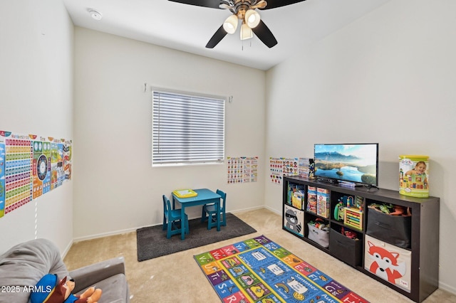 recreation room featuring light carpet, baseboards, and a ceiling fan