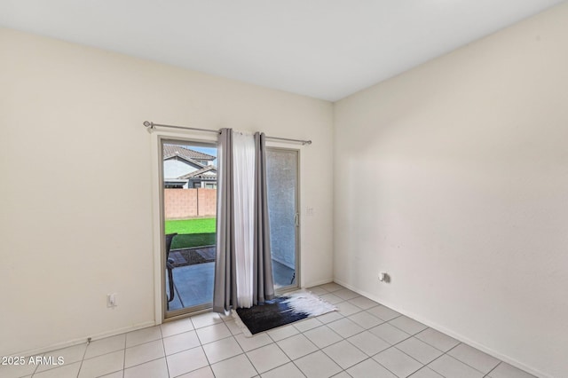 spare room with baseboards and light tile patterned floors