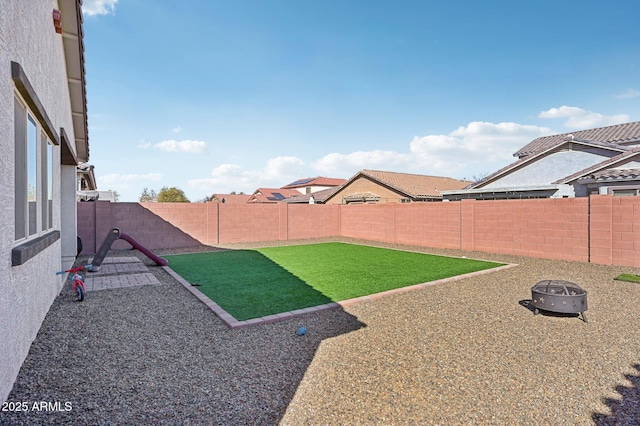 view of yard featuring a patio area, a fenced backyard, and a fire pit