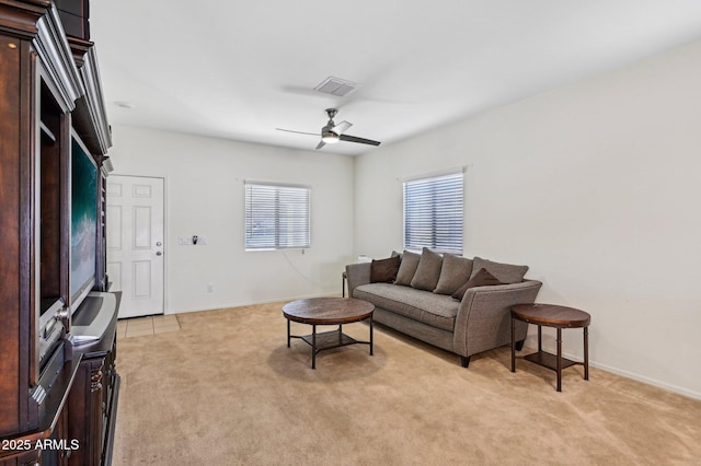 living area featuring ceiling fan, visible vents, baseboards, and light colored carpet