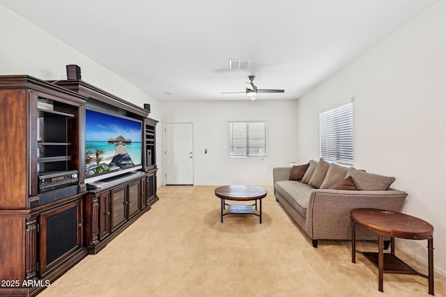 living area featuring light colored carpet, visible vents, and ceiling fan