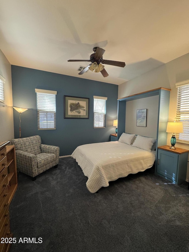 bedroom featuring dark colored carpet, multiple windows, ceiling fan, and visible vents