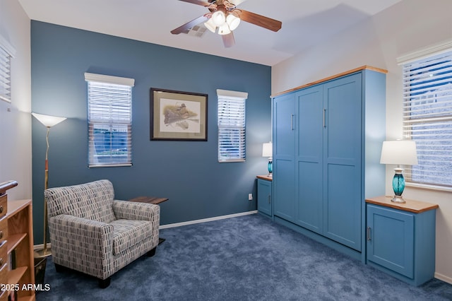 living area featuring a ceiling fan, visible vents, dark carpet, and baseboards