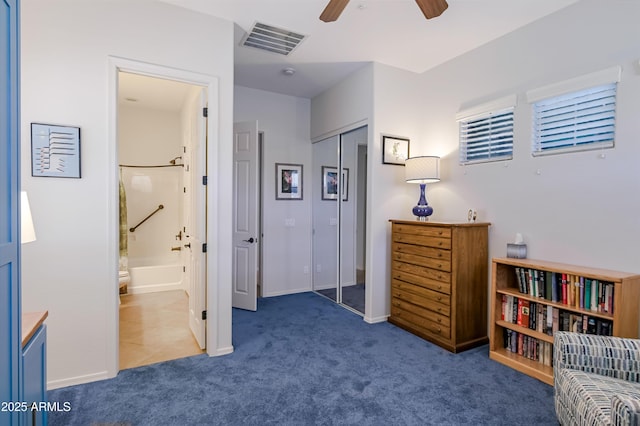 interior space featuring ensuite bathroom, visible vents, baseboards, a closet, and dark colored carpet