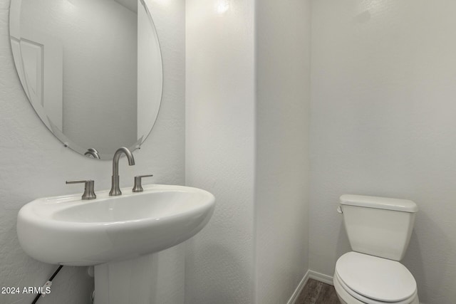 bathroom featuring sink, wood-type flooring, and toilet