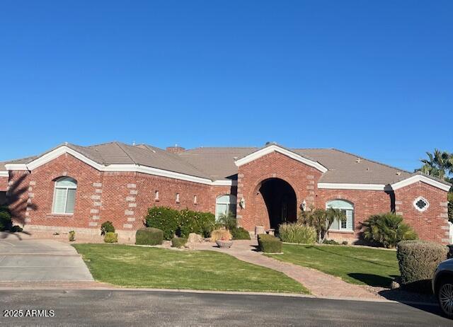 view of front of house with a front lawn and brick siding