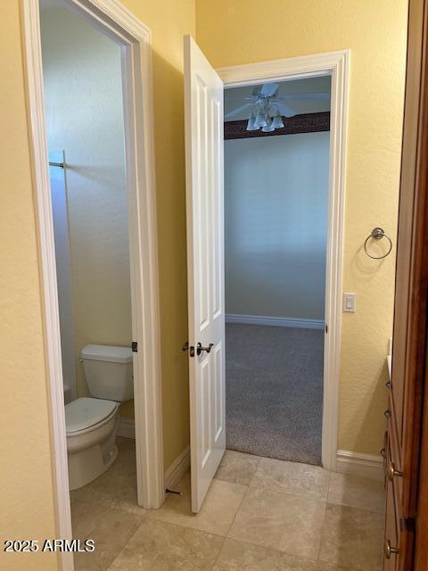 bathroom featuring baseboards, toilet, and tile patterned floors