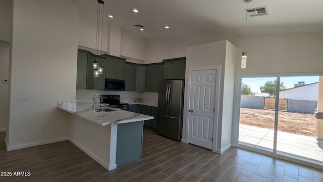 kitchen featuring decorative light fixtures, kitchen peninsula, sink, a high ceiling, and stainless steel appliances