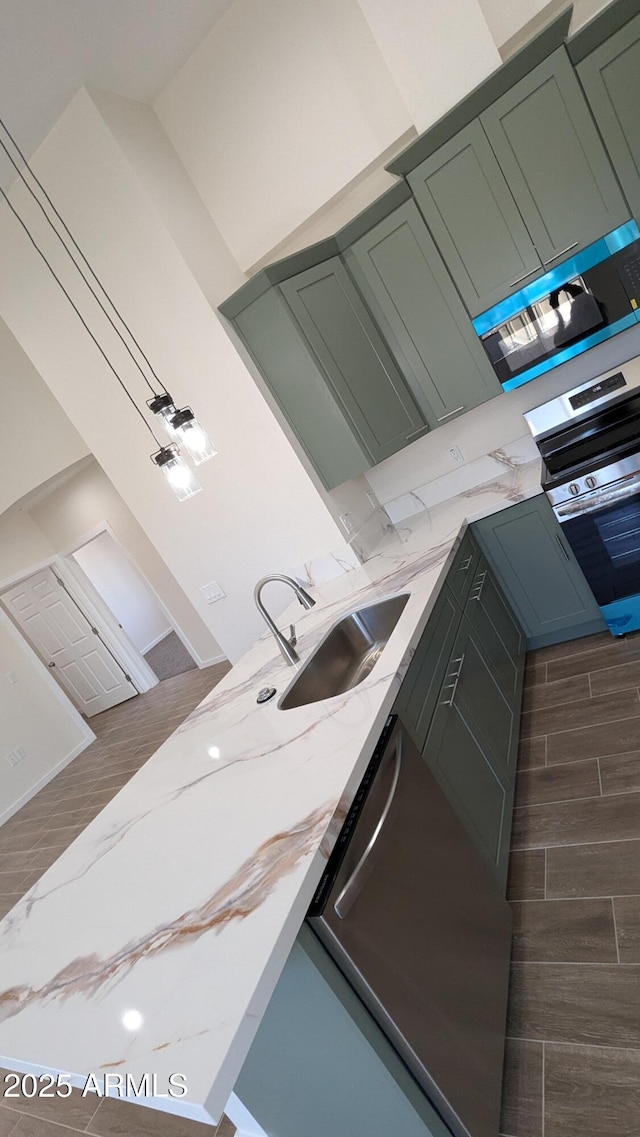 kitchen with light stone countertops, sink, and green cabinets