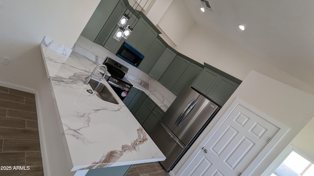 kitchen featuring light stone counters, sink, green cabinets, and a high ceiling