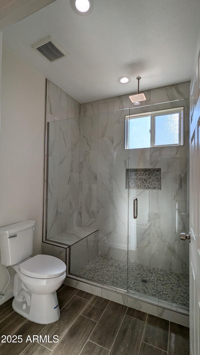 bathroom with walk in shower and toilet