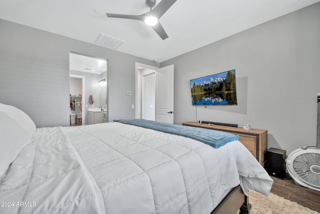 bedroom with ensuite bath, ceiling fan, and dark wood-type flooring