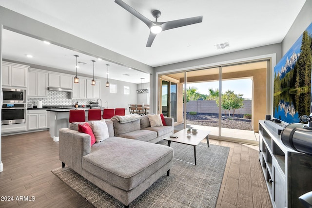 living room featuring ceiling fan and dark wood-type flooring