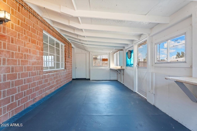 unfurnished sunroom featuring beamed ceiling