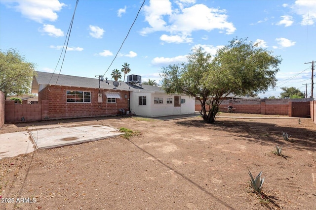 back of house featuring fence, central AC unit, a patio area, and brick siding