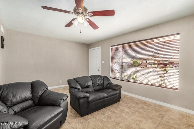 living room with baseboards, a ceiling fan, and light tile patterned flooring