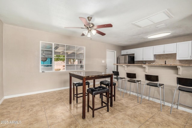 dining room with a ceiling fan, baseboards, visible vents, and light tile patterned floors