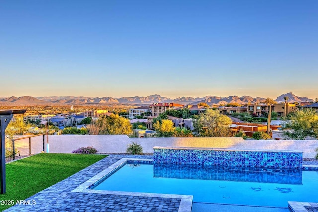 pool at dusk with a mountain view and a patio area