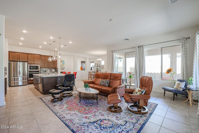 tiled living room with sink and a chandelier