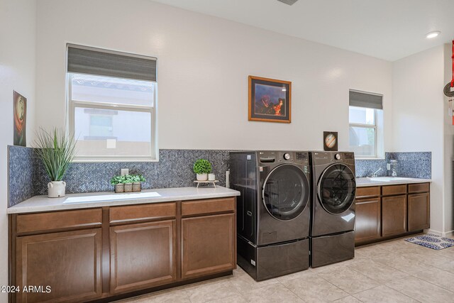 washroom with washer and dryer, cabinets, sink, and light tile patterned flooring