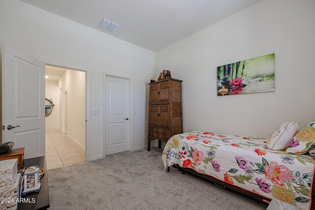 bedroom with light carpet and lofted ceiling