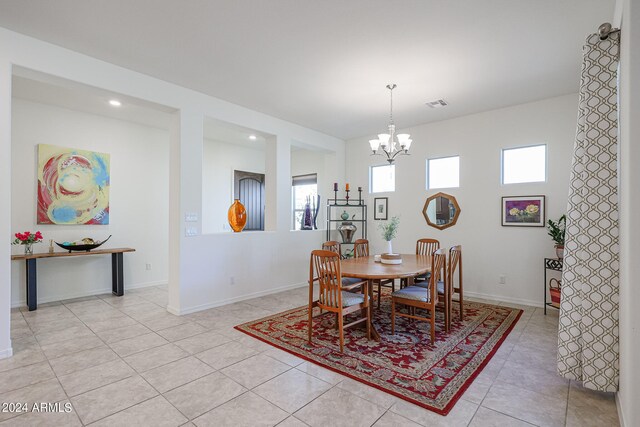 tiled dining space featuring an inviting chandelier and plenty of natural light