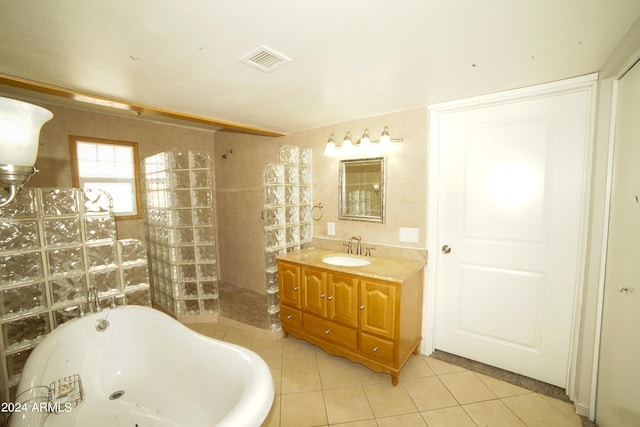 bathroom featuring vanity, tile patterned flooring, shower with separate bathtub, and tile walls